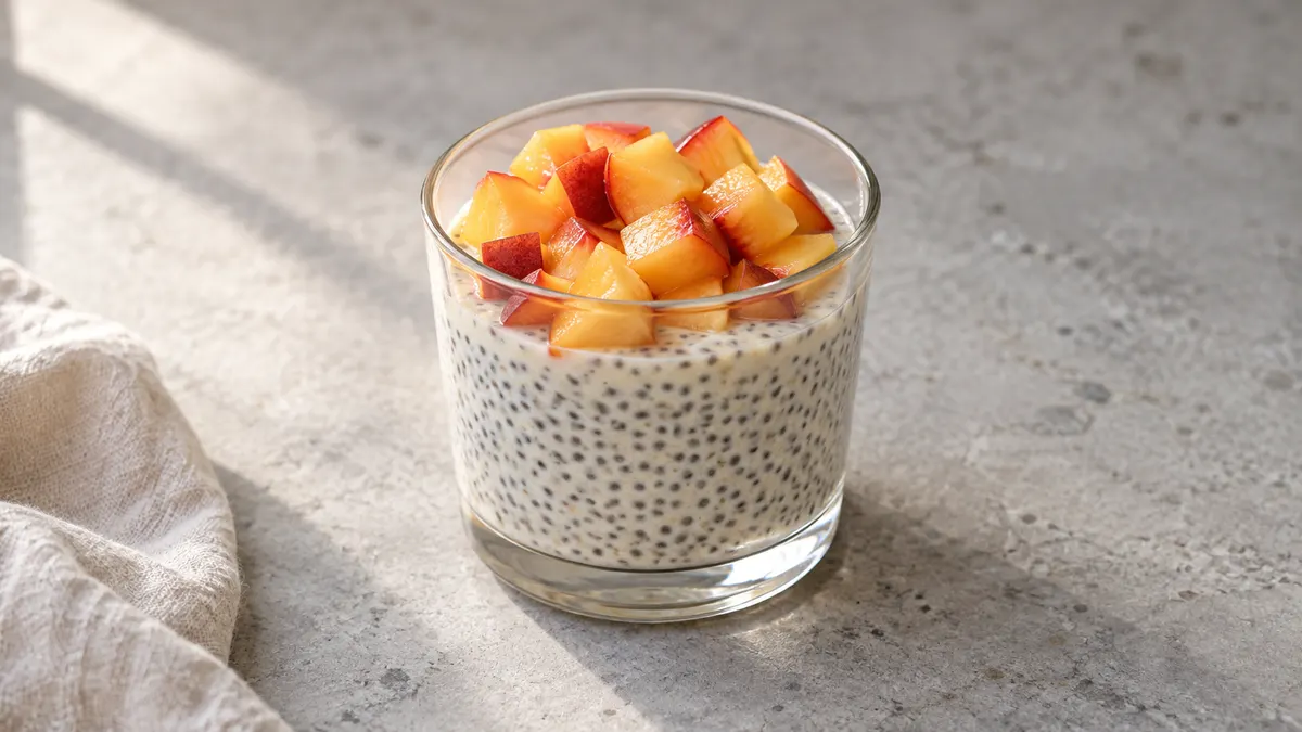 Peach chia yogurt pot served in a small portion on pale stone