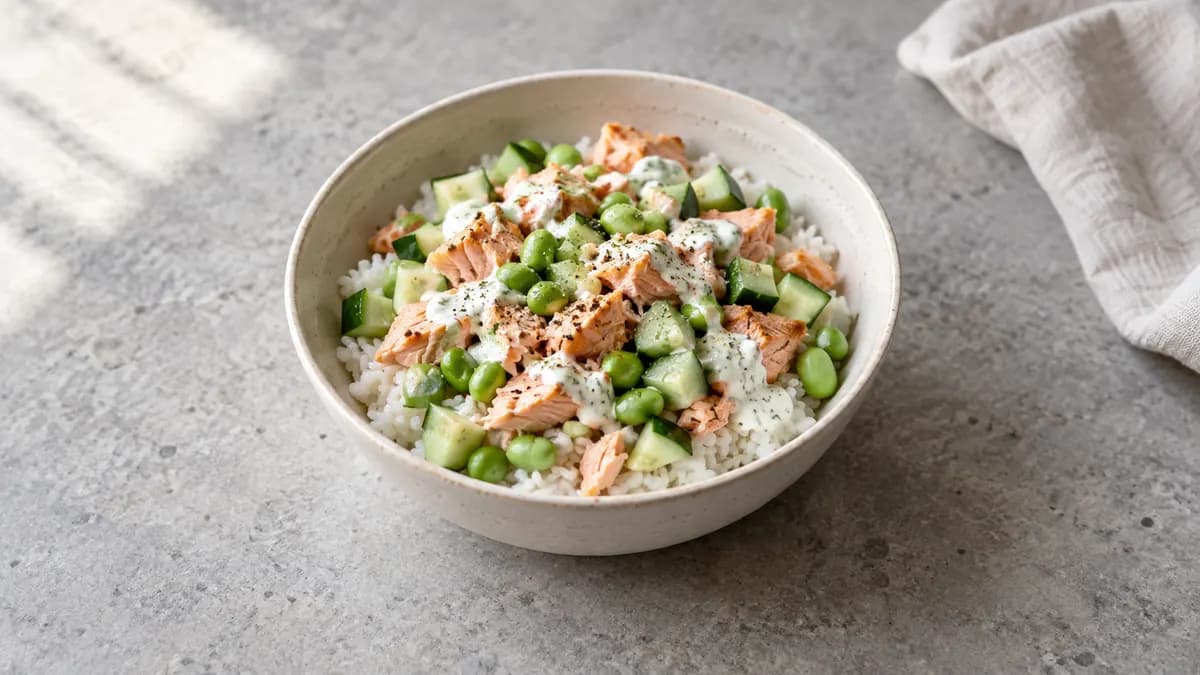 Salmon cucumber rice bowl served in a small portion on pale stone
