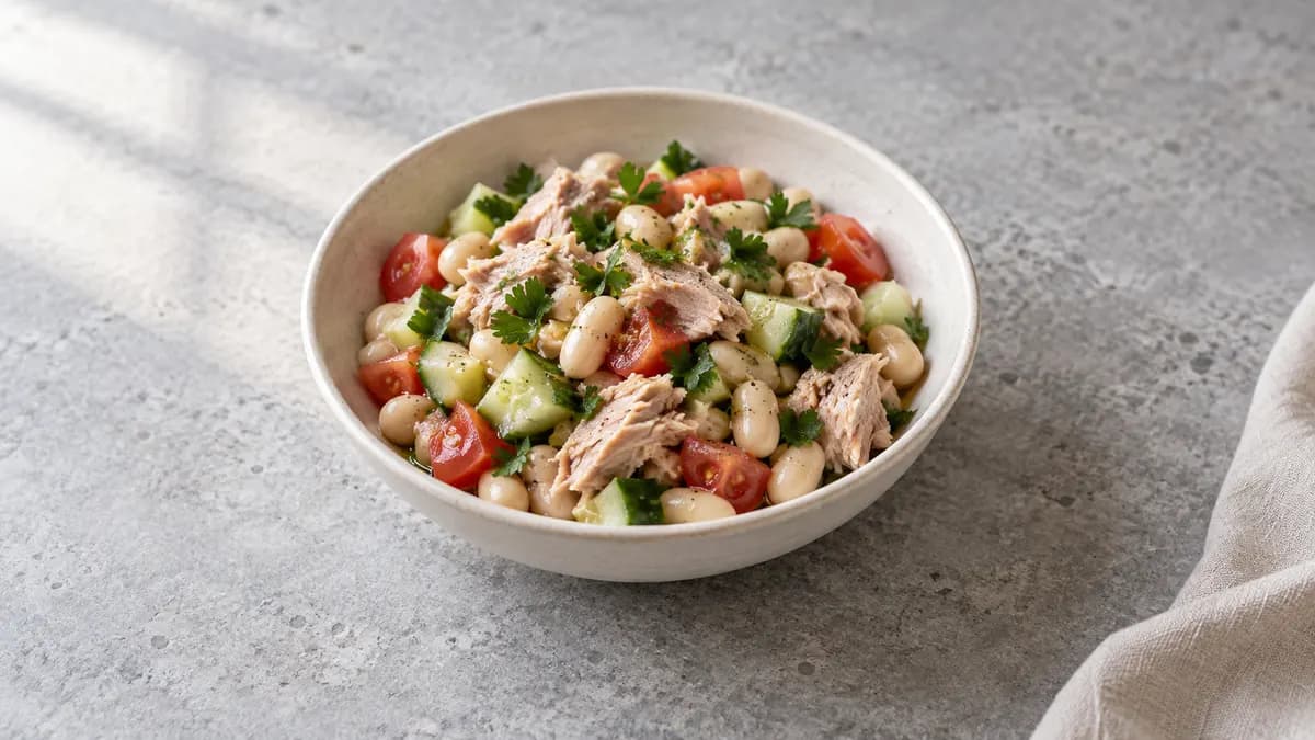 Tuna and white bean salad served in a small portion on pale stone