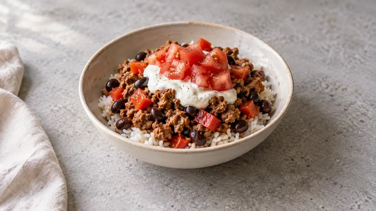 Turkey black bean taco bowl served in a small portion on pale stone